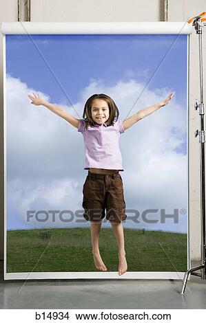 Girl standing with arms up on grass with blue sky View Large Photo Image Picture - Girl standing with arms up on grass with blue sky. Fotosearch