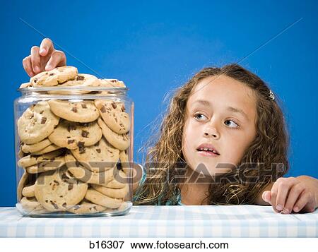 Girl taking chocolate chip cookie from jar View Large Photo Image Stock Photo - Girl taking chocolate chip cookie from jar. Fotosearch