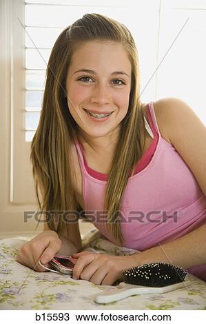 Girl with braces on bed with hairbrush smiling View Large Photo Image Stock Image - Girl with braces on bed with hairbrush smiling. Fotosearch