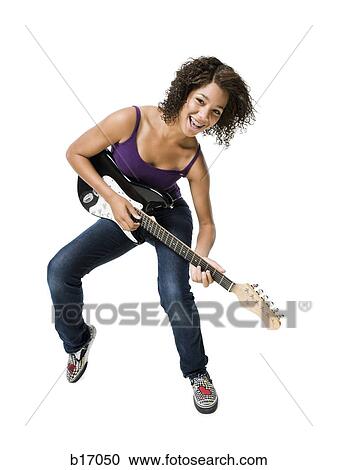 Stock Image - Girl with braces playing electric guitar smiling. Fotosearch