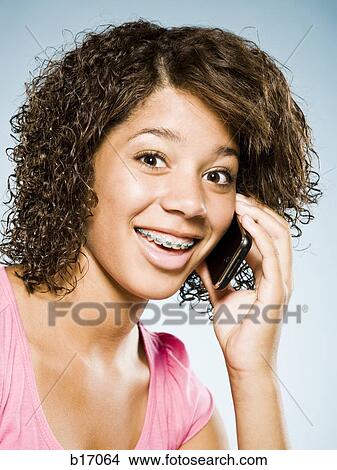 Girl with braces talking on cell phone smiling View Large Photo Image Picture - Girl with braces talking on cell phone smiling. Fotosearch