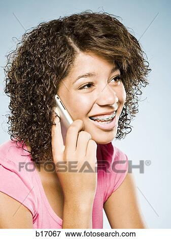 Girl with braces talking on cell phone smiling View Large Photo Image Stock Photo - Girl with braces talking on cell phone smiling. Fotosearch