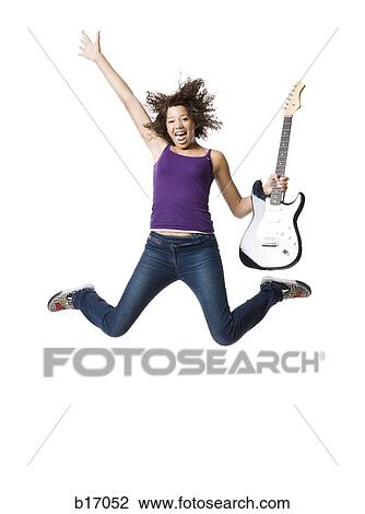 Girl with electric guitar jumping and smiling with arm up View Large Photo Image Stock Image - Girl with electric guitar jumping and smiling with arm up. Fotosearch