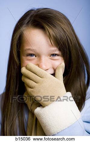 Girl with mittens covering mouth and smiling View Large Photo Image Stock Photograph - Girl with mittens covering mouth and smiling. Fotosearch