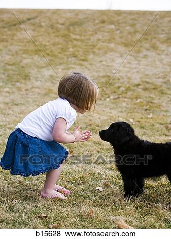 Stock Photo - Girl with puppy outdoors. Fotosearch