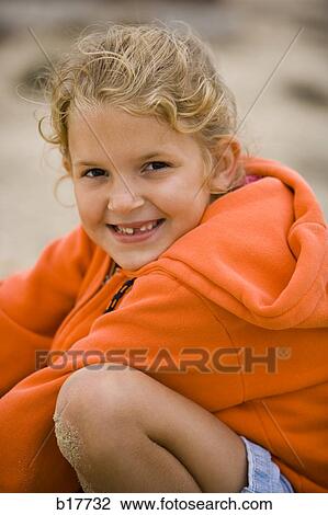Stock Image - Girl with sand on knee smiling. Fotosearch