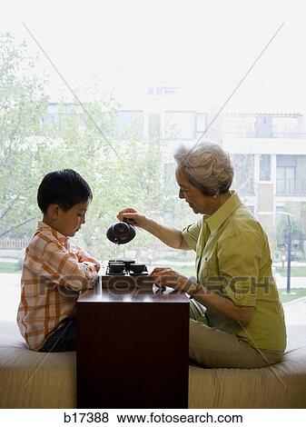 Grandmother and grandson sitting cross legged drinking tea View Large Photo Image Stock Photo - Grandmother and grandson sitting cross legged drinking tea. Fotosearch