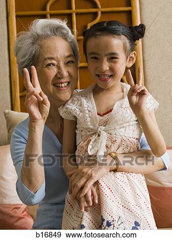 Grandmother with granddaughter making peace signs and smiling View Large Photo Image Stock Photo - Grandmother with granddaughter making peace signs and smiling. Fotosearch