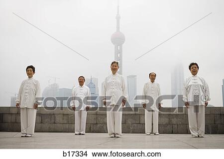 Group doing tai chi outdoors with city skyline in background View Large Photo Image Picture - Group doing tai chi outdoors with city skyline in background. Fotosearch