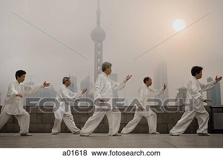 Group doing tai chi outdoors with city skyline in background View Large Photo Image Stock Photo - Group doing tai chi outdoors with city skyline in background. Fotosearch