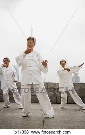 Group doing tai chi outdoors with city skyline in background View Large Photo Image Stock Photo - Group doing tai chi outdoors with city skyline in background. Fotosearch
