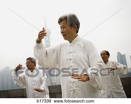 Group doing tai chi outdoors with city skyline in background View Large Photo Image Stock Photo - Group doing tai chi outdoors with city skyline in background. Fotosearch