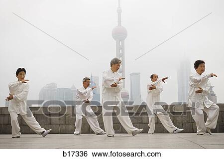 Group doing tai chi outdoors with city skyline in background View Large Photo Image Stock Photograph - Group doing tai chi outdoors with city skyline in background. Fotosearch