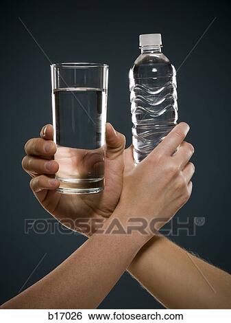 Hand holding glass of water and hand holding bottled water intertwined View Large Photo Image Stock Photograph - Hand holding glass of water and hand holding bottled water intertwined. Fotosearch