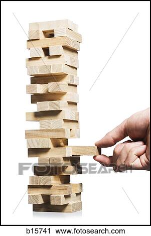 Hand removing block from stack of wooden blocks View Large Photo Image Stock Image - Hand removing block from stack of wooden blocks. Fotosearch