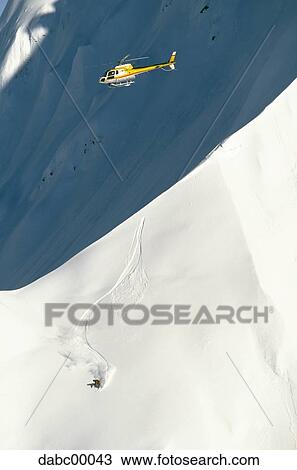 Helicopter and snowboarder on mountain in winter View Large Photo Image Stock Image - Helicopter and snowboarder on mountain in winter. Fotosearch