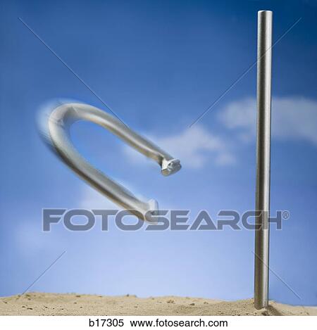 Stock Photography - Horseshoe and peg with motion blur and blue sky. Fotosearch