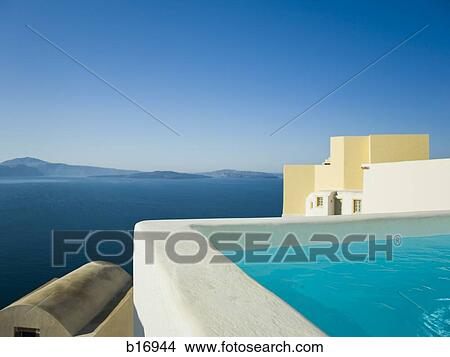 Infinity pool with mountains and water in background View Large Photo Image Picture - Infinity pool with mountains and water in background. Fotosearch