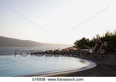 Stock Photo - Infinity pool with mountains and water in background. Fotosearch