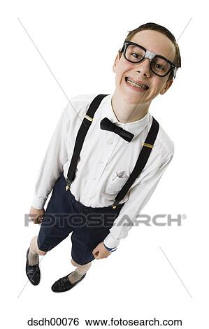 Stock Photograph - Male nerd with suspenders and tape on eyeglasses smiling with braces. Fotosearch