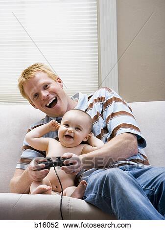 Man and baby on sofa with video game controller smiling View Large Photo Image Stock Image - Man and baby on sofa with video game controller smiling. Fotosearch