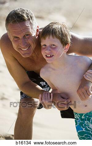Man and boy outdoors in swimming trunks View Large Photo Image Picture - Man and boy outdoors in swimming trunks. Fotosearch