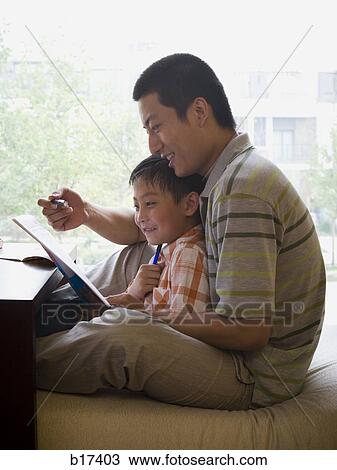 Man and boy sitting and reading in front of large window View Large Photo Image Stock Image - Man and boy sitting and reading in front of large window. Fotosearch