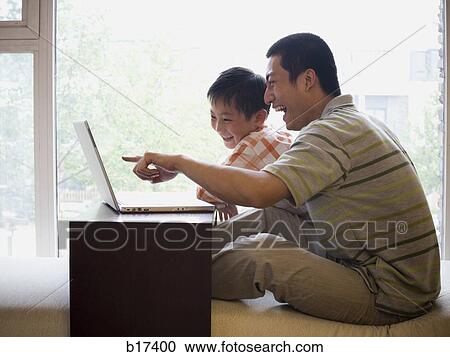 Man and boy sitting at computer View Large Photo Image Stock Image - Man and boy sitting at computer. Fotosearch