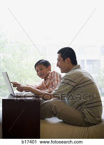 Man and boy sitting at computer View Large Photo Image Stock Image - Man and boy sitting at computer. Fotosearch