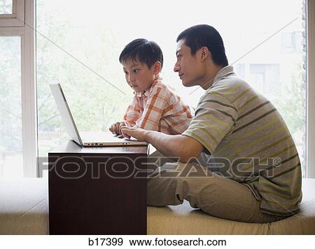 Man and boy sitting at computer View Large Photo Image Stock Photo - Man and boy sitting at computer. Fotosearch