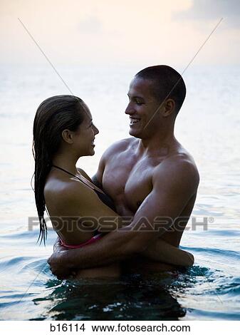 Man and woman embracing in water smiling View Large Photo Image Picture - Man and woman embracing in water smiling. Fotosearch