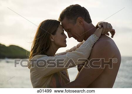Man and woman hugging outdoors on beach View Large Photo Image Stock Photo - Man and woman hugging outdoors on beach. Fotosearch