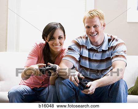 Man and woman on sofa playing video games View Large Photo Image Stock Photo - Man and woman on sofa playing video games. Fotosearch