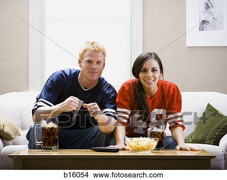 Man and woman on sofa watching television View Large Photo Image Picture - Man and woman on sofa watching television. Fotosearch