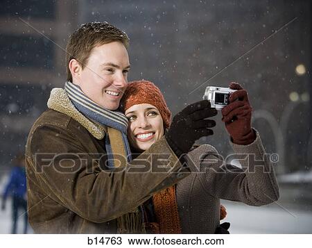 Man and woman taking a photo outdoors in winter View Large Photo Image Stock Image - Man and woman taking a photo outdoors in winter. Fotosearch