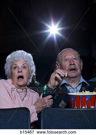 Man and woman watching film at movie theatre frightened View Large Photo Image Stock Photo - Man and woman watching film at movie theatre frightened. Fotosearch