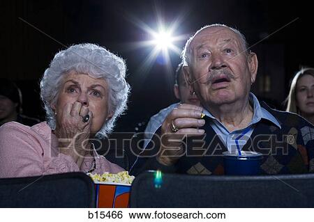 Man and woman watching film at movie theatre frightened View Large Photo Image Stock Photograph - Man and woman watching film at movie theatre frightened. Fotosearch