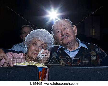 Man and woman watching movie in theater crying with popcorn View Large Photo Image Stock Photography - Man and woman watching movie in theater crying with popcorn. Fotosearch