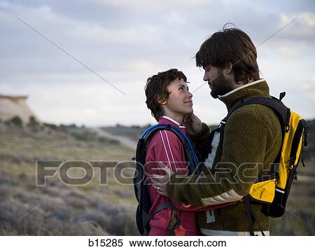 Man and woman with backpacks embracing outdoors View Large Photo Image Stock Photography - Man and woman with backpacks embracing outdoors. Fotosearch