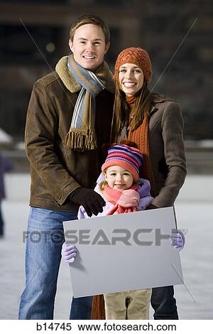 Man and woman with girl holding blank sign outdoors in winter View Large Photo Image Stock Photography - Man and woman with girl holding blank sign outdoors in winter. Fotosearch