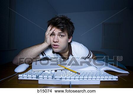 Man at keyboard with pencil and papers with hand on head View Large Photo Image Picture - Man at keyboard with pencil and papers with hand on head. Fotosearch