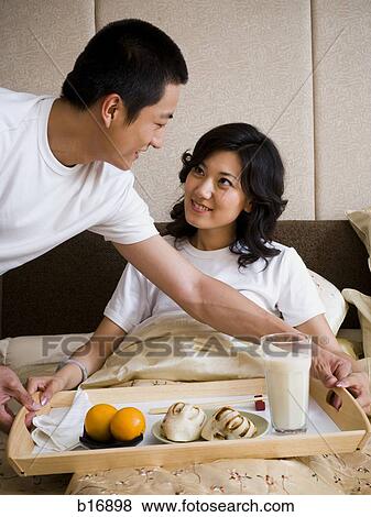 Man bringing woman breakfast in bed View Large Photo Image Stock Photo - Man bringing woman breakfast in bed. Fotosearch