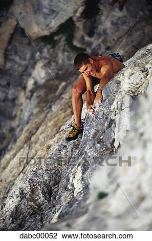Stock Image - Man climbing mountain. Fotosearch