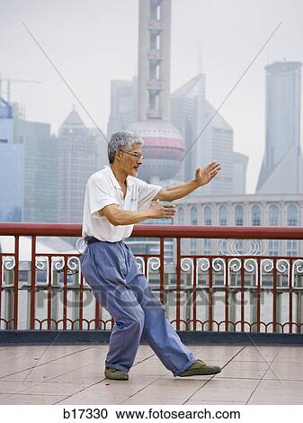 Man doing tai chi outdoors with city skyline in background View Large Photo Image Stock Image - Man doing tai chi outdoors with city skyline in background. Fotosearch