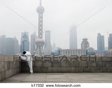 Man doing tai chi outdoors with city skyline in background View Large Photo Image Stock Image - Man doing tai chi outdoors with city skyline in background. Fotosearch