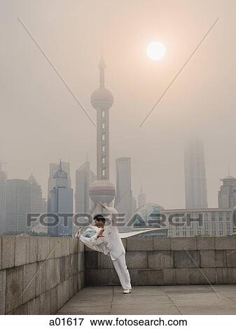 Man doing tai chi outdoors with city skyline in background View Large Photo Image Stock Photo - Man doing tai chi outdoors with city skyline in background. Fotosearch