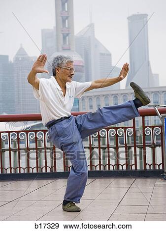 Man doing tai chi outdoors with city skyline in background View Large Photo Image Stock Photo - Man doing tai chi outdoors with city skyline in background. Fotosearch