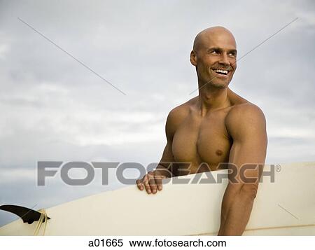 Stock Photography - Man holding a surfboard.. Fotosearch