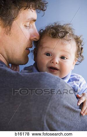 Stock Photo - Man holding baby boy looking frightened. Fotosearch