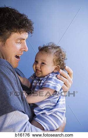 Man holding baby boy smiling View Large Photo Image Stock Photograph - Man holding baby boy smiling. Fotosearch